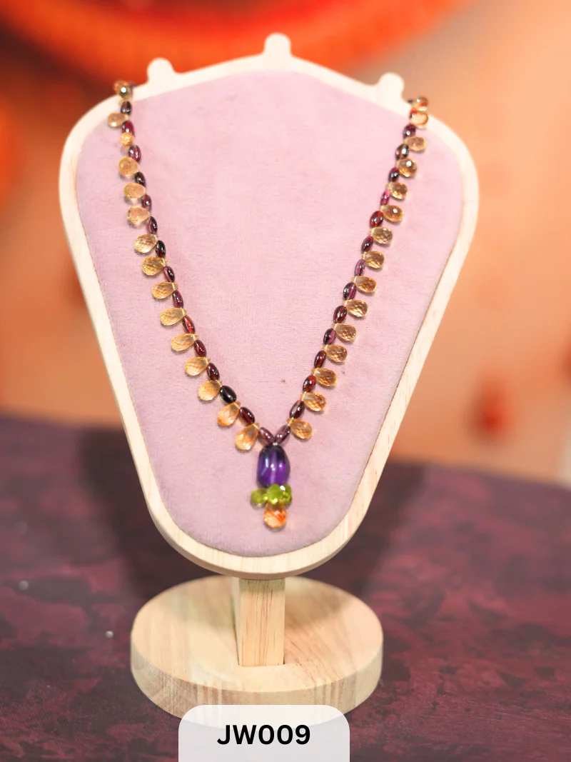 The necklace features a vibrant mix of briolette-cut semi-precious gemstones, including amethyst, peridot, citrine, and garnet